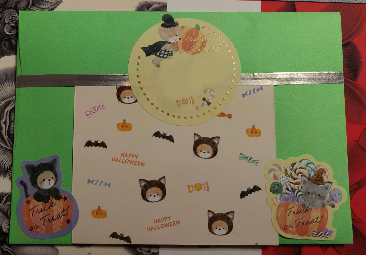 a photo of the back of a bright green envelope. it has various cute halloween stickers on it.