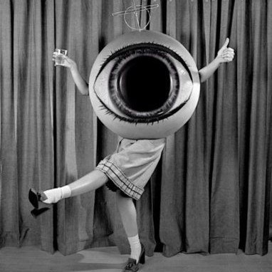 black and white image of a person in a giant eyeball costume